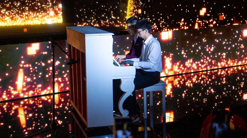 智能仿生手使用者古月與少年鋼琴家舒海峰合奏。主辦方供圖