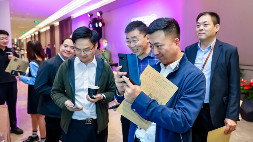 人民網(wǎng)研發(fā)推出的《人民日?qǐng)?bào)》生日?qǐng)?bào)吸引嘉賓體驗(yàn)。主辦方供圖