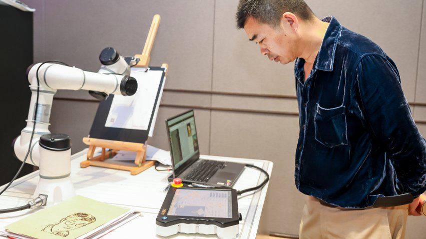 嘉賓體驗(yàn)遨博AI繪畫機(jī)器人。主辦方供圖